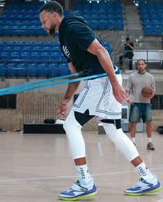 a man holding a basketball in his right hand while standing on top of a basketball court