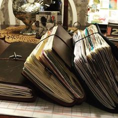 a pile of papers sitting on top of a table next to a binder and pen