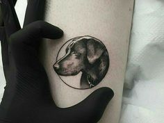 a person with a tattoo on their arm that has a dog's head in the circle