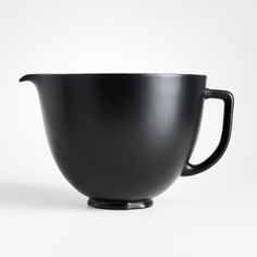 a black cup sitting on top of a white table