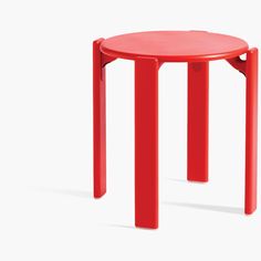 a small red table with two legs that are bent to one side and the other end