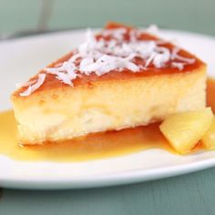 a piece of cake on a white plate topped with coconut syrup and powdered sugar