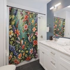 a bathroom with two shower curtains and a sink in front of the bathtub is decorated with colorful flowers