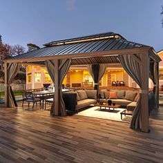 an outdoor living area with wood flooring and covered patio furniture at dusk, lit up by the evening sun