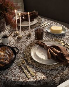 the table is set with plates, silverware and candles