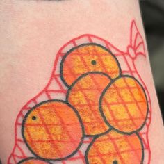 a close up of a person's leg with oranges on it and red lines