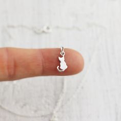 Tiny Sterling Silver Sitting Cat Necklace. This charm necklace featuring a sweet kitty sitting patiently with a tiny curled tail is just the thing for animal lovers. Take this little cat home with you and it will be sure to bring a smile to your face and warmth to your heart! » Sterling Silver Cat Charm (15mm x 6mm) with tiny 925 genuine Sterling mark on back. » Sterling Silver Cable Chain (select from drop-down on upper right) » Your jewelry purchase will come beautifully packaged for gift givi Cat Necklace Gold, Cat Charm Necklace, Cat Necklace Silver, Lovers Jewelry, Lover Necklace, Cat Pendant Necklace, Pendant Necklace Simple, Minimalist Accessories, Lovers Necklace