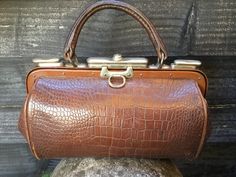 Old doctor's bag made of brown leather with snakeskin motif, made around 1920s - 1930s This old bag has 1 compartment with 1 side pocket. It looks neat inside the bag. There may be some light signs of use from medicinal ointments The handle of the bag is in the same color as the leather of the bag, the clasps, hinges and locks are made of silver-colored metal. If the bag is facing you with the hanging eye (as in the 1st photo), you can slide the wide button to the right to open the bag. The mechanism works smoothly. The key is no longer present. This is a beautiful bag with 1 notable flaw. The leather has a tear on the fold on the right side (from the front). see the pictures. Dimensions: 16 cm high... including handle 22 cm high x 27.5 cm long x 9 cm wide. To view more decorative items, c Textile Interior, Pocket Watch Necklace, Silver Pocket Watch, Doctor Bag, Watch Necklace, Louis Vuitton Speedy Bag, Beautiful Bags, Side Pocket, Snake Print