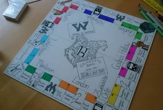 a close up of a board game on a table with markers and pencils next to it