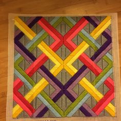 a close up of a colorful quilt on a wooden floor