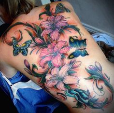 a woman's back with flowers and butterflies on it