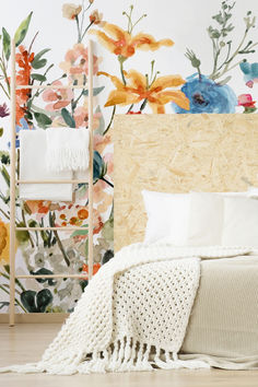 a bedroom with floral wallpaper and white bedding, along with a wooden headboard