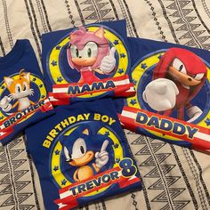 three sonic the hedgehog birthday shirts on a bed