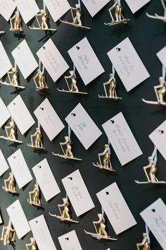 many small figurines are placed on the wall with name tags attached to them