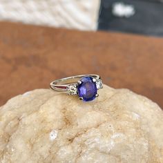 Vintage/ estate 14KT white gold oval-cut, faceted, violet tanzanite + diamond ring. Faceted, genuine, deep violet blue tanzanite prong set in 14KT white gold. Size 6.75 Can be resized for an additional fee Tanzanite measures: 9mm x 7mm Approximately 2.25-2.70 CT tanzanite 2 Round-cut, natural diamonds .15 CT per diamond; SI2 clarity; J/K color Weight: 3.88 grams Stamped 14K Evil Eye Hand, Saint Jewelry, Tanzanite Diamond Ring, Diamond Accent Ring, Tanzanite Diamond, Tanzanite Ring, Blue Tanzanite, Round Cut Diamond, Oval Cut