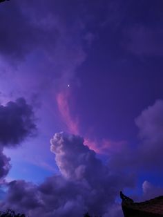 the sky is filled with clouds and purple hues