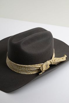 This raw edge golden paisley fabric band adds a touch of boho style to any hat while offering security for your favorite feathers. Tie in a knot or bow to your liking. Details 100-percent cotton 34" total length Luxury Leather Hat Band For Flat Crown, Bandana Hat Band, Cowboy Hat Bands With Tabs, Luxury Adjustable Country Style Hat Band, Elegant Fitted Hat Bands For Festivals, Classic Fitted Hat Bands For Festivals, Classic Fitted Festival Hat Bands, Adjustable Gold Hat Band For Kentucky Derby, Gold Bohemian Hat Band For Rodeo