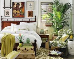 a bed sitting in a bedroom next to a green chair and potted palm tree