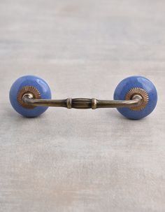 an antique brass and blue door handle on a white surface with light colored wood grain