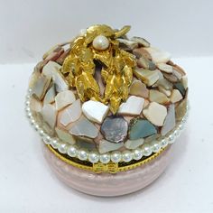 a decorative box with pearls and gold leaf brooch