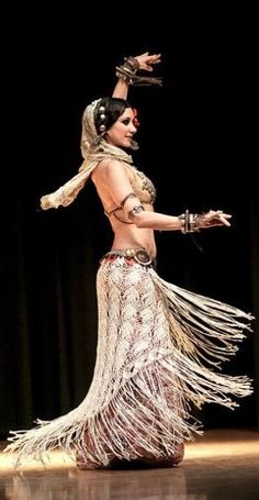 a woman in a belly dance costume on stage