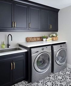 a washer and dryer in a kitchen with black cabinets