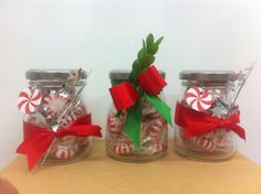 three glass jars filled with candy canes and candies