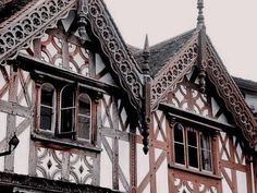 an old building with two story windows and ornate woodwork on the front, side and top