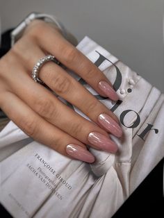 a woman's hand with pink and white manies on top of a magazine