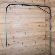 the inside of a wooden room with wood paneling and blue piping on the wall