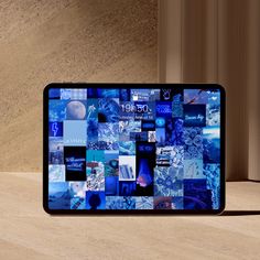 a cell phone sitting on top of a wooden table next to a wall covered in pictures