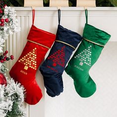 three christmas stockings hanging from a fireplace