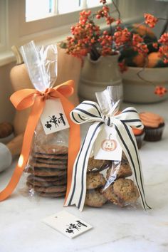 some cookies are wrapped in cellophane and tied with orange ribbon on the counter