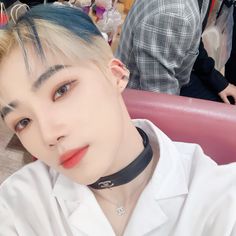 a man with blue hair wearing a black choker