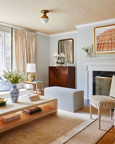 a living room filled with furniture and a fire place in front of a painting on the wall