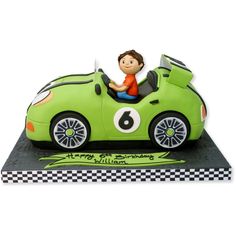 a green car cake with a boy in the driver's seat