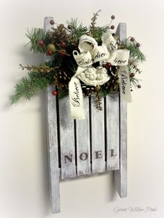 a wooden sled with flowers and greenery on the top is hung on a wall