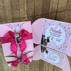 an open pink box with a small doll in the center and a card inside it