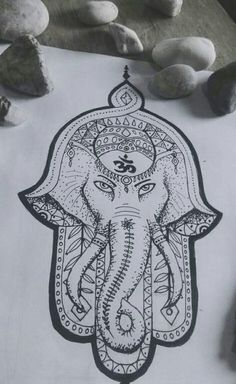 an elephant drawn in black and white on a piece of paper with rocks around it