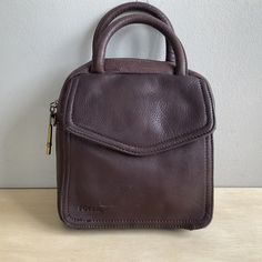 "This Fossil purse is in good condition, there is minimal wear to the leather. There is a scrape on one of the handles (last pic).  This purse is used and there could be some small defect that I missed. I am including a crossbody strap that is not original to the purse, it is a different color and not leather. Please look at the pictures as they are part of my description. Thanks for your interest. 👜🌺 Measurements are approximate. 7 1/2\" Depth Bottom measures 7x3\" 16 oz #597" Brown Crossbody Bag Fossil, Original Barbie Doll, Fossil Purse, Gold Belts, Top Handle Bags, Belt Purse, Black Leather Purse, I Missed, Crossbody Strap