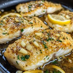 some fish and lemons are cooking in a pan