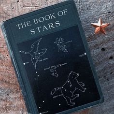 the book of stars sits on top of a wooden table