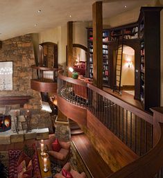 a living room filled with lots of furniture and a fire place next to a stone wall