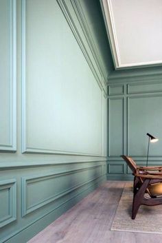 an empty room with green walls and wooden furniture