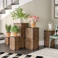 a living room filled with lots of furniture and flowers on top of wooden boxes next to a stair case