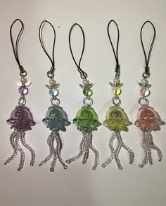 four different colored jellyfish charms hanging from black cord