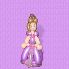 a balloon shaped like a princess sitting on top of a purple background