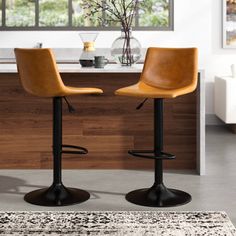 two brown leather bar stools in front of a counter with a vase on it