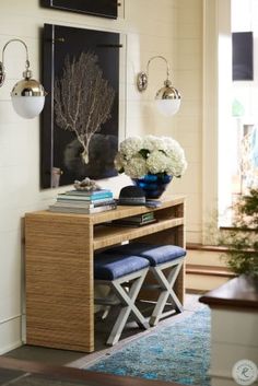 a living room filled with furniture and flowers on top of a wooden table in front of a window