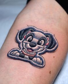 a tattoo on the arm of a person with a cartoon dog in it's lap